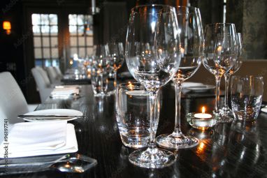 Investeren Gunst bundel sfeervol gedekte tafel met wijnglazen, borden en bestek in een restaurant  #96197741 - Tuinposter