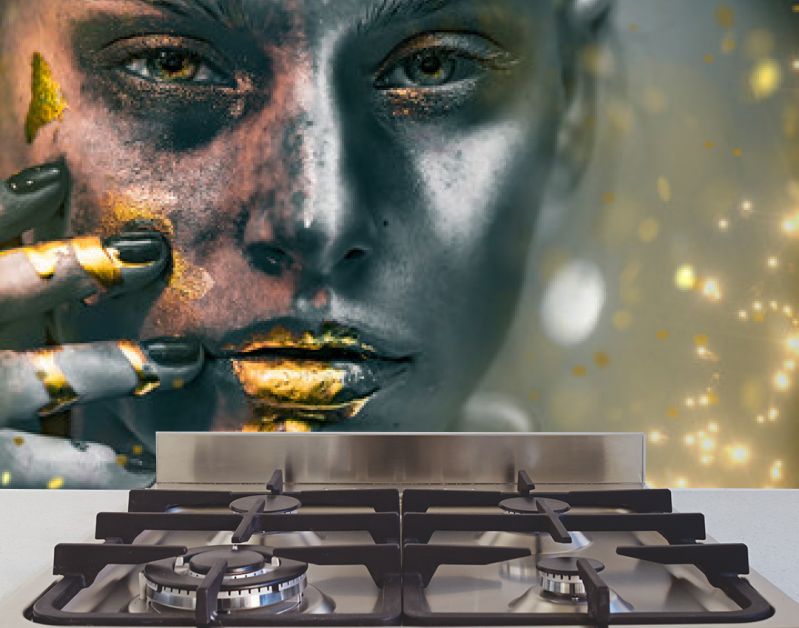 Gouden verfvlekken druipen van het gezicht, de lippen en de hand van de vrouw, lipgloss druipt van sexy lippen, gouden vloeistofdruppels op de mond van een mooi modelmeisje, gouden metalen huidmake-up. Schoonheid vrouw make-up close