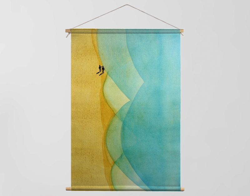 Twee wandelaars op strand bij turquoise zee