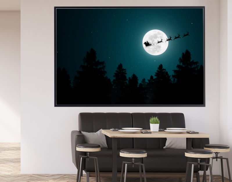 Santa Claus flying in his sleigh over the moon