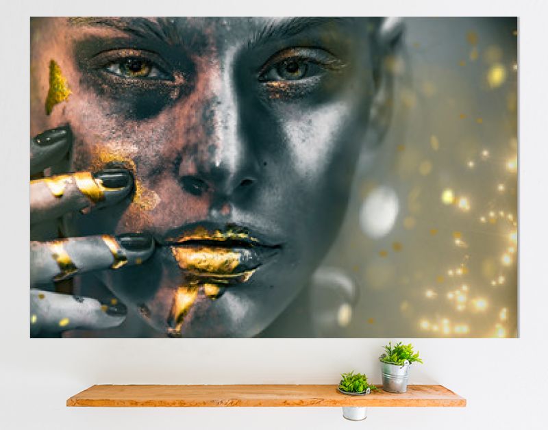 Gouden verfvlekken druipen van het gezicht, de lippen en de hand van de vrouw, lipgloss druipt van sexy lippen, gouden vloeistofdruppels op de mond van een mooi modelmeisje, gouden metalen huidmake-up. Schoonheid vrouw make-up close