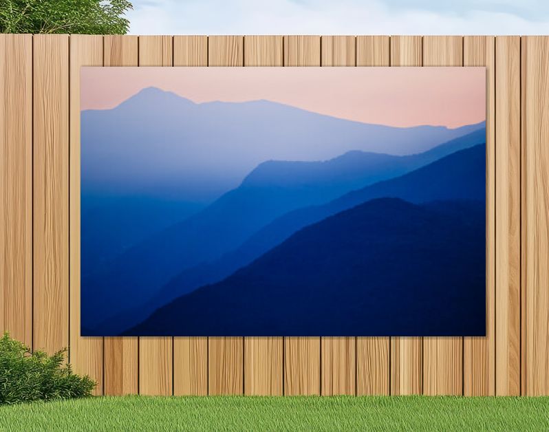 Stacked silhouettes of blue mountains underneath an orange evening sky at Lago Maggiore, Italy close to Switzerland. Original image with minimalist appearance. Ideal background with large copy space.