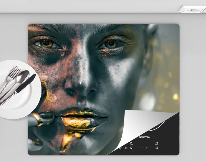 Gouden verfvlekken druipen van het gezicht, de lippen en de hand van de vrouw, lipgloss druipt van sexy lippen, gouden vloeistofdruppels op de mond van een mooi modelmeisje, gouden metalen huidmake-up. Schoonheid vrouw make-up close