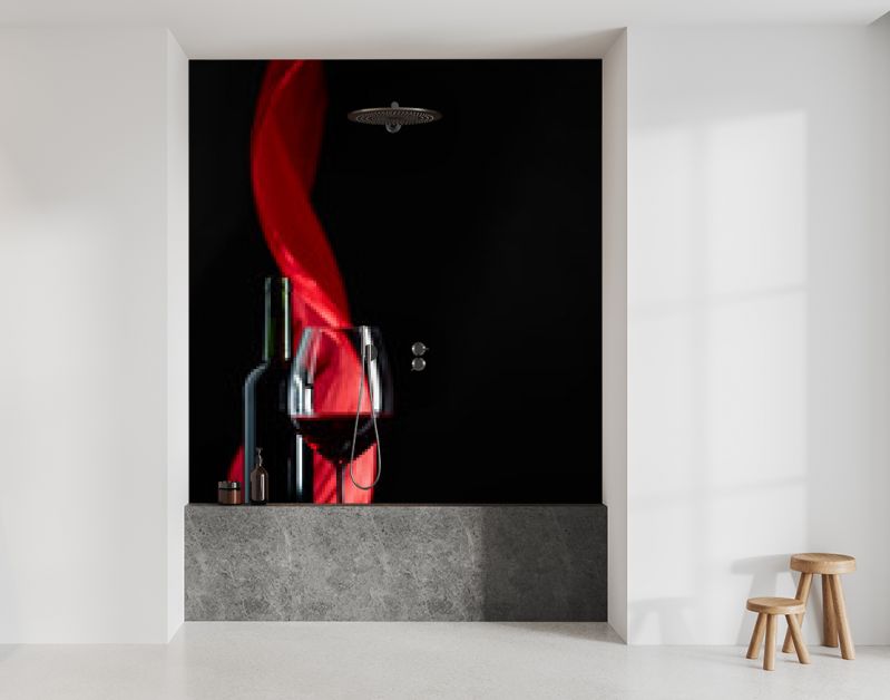 Wineglass and bottle of red wine on a black reflective background.