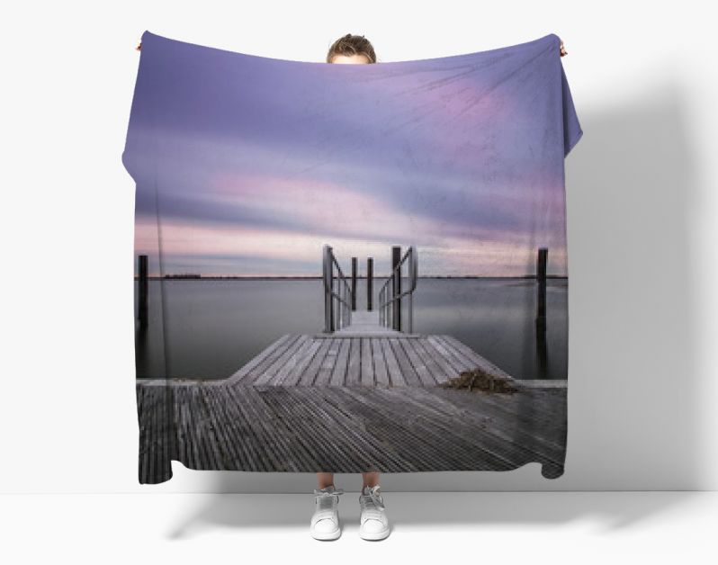 Een leeg, vredig dok in een jachthaven terwijl wolken door de lucht schieten. Stilstaand water, serene en kalme scène