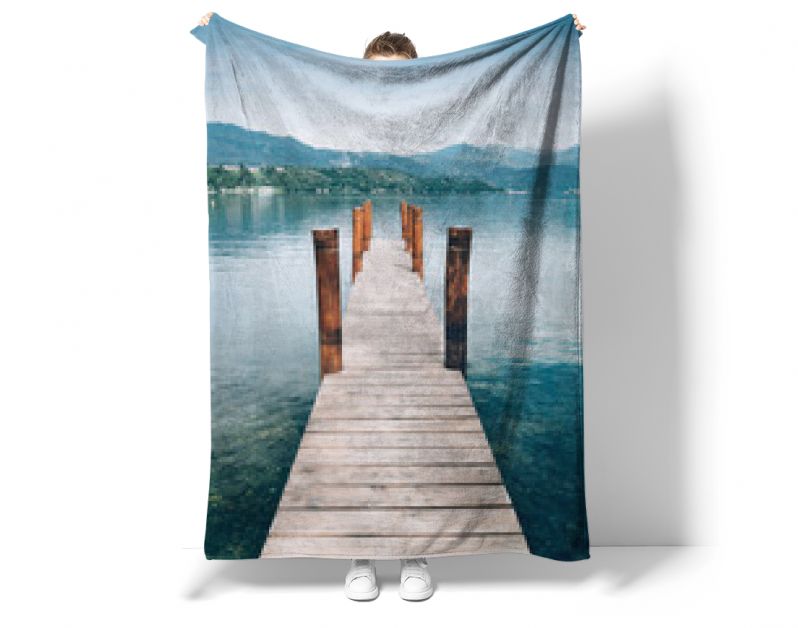 Houten pier op het meer van Orta San Giulio met een groene bergachtergrond. Italië.