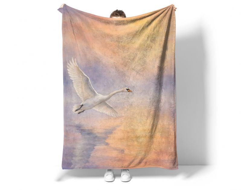 Witte zwaan in vlucht boven water bij zonsopkomst