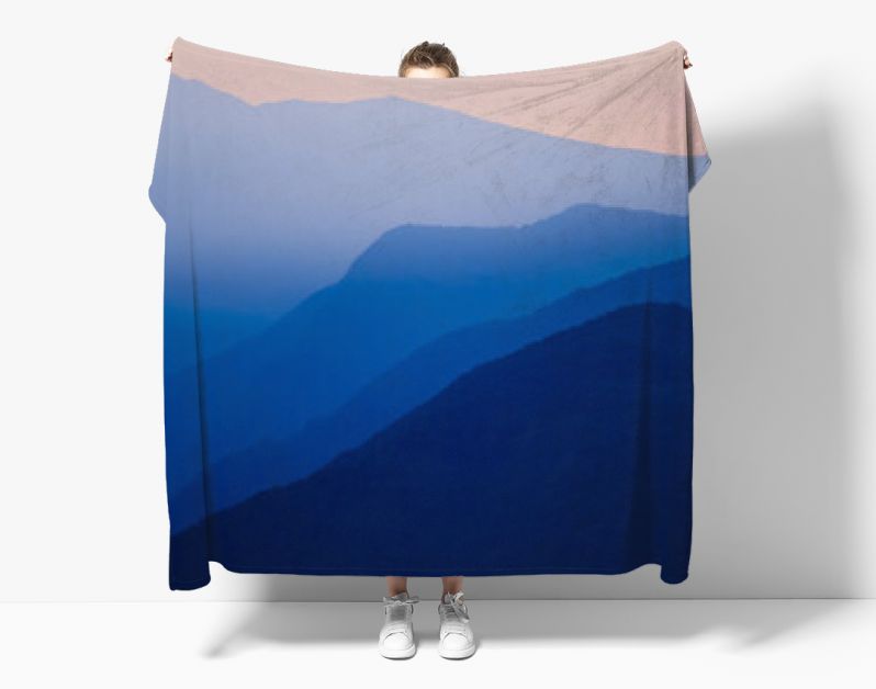 Stacked silhouettes of blue mountains underneath an orange evening sky at Lago Maggiore, Italy close to Switzerland. Original image with minimalist appearance. Ideal background with large copy space.