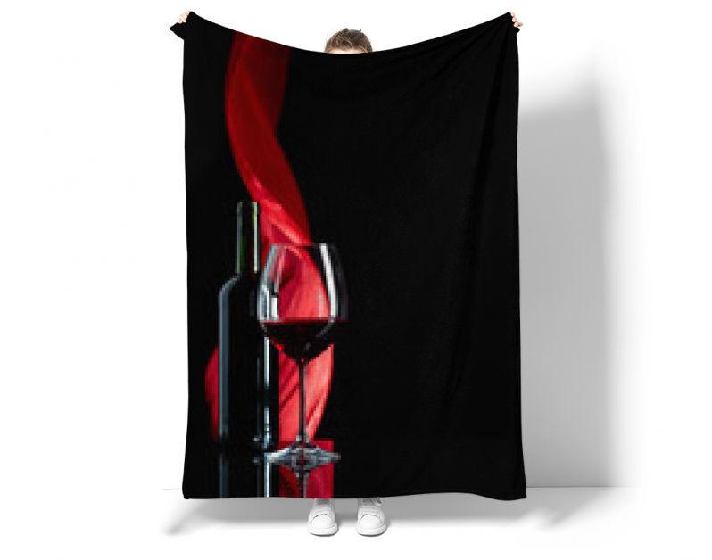 Wineglass and bottle of red wine on a black reflective background.